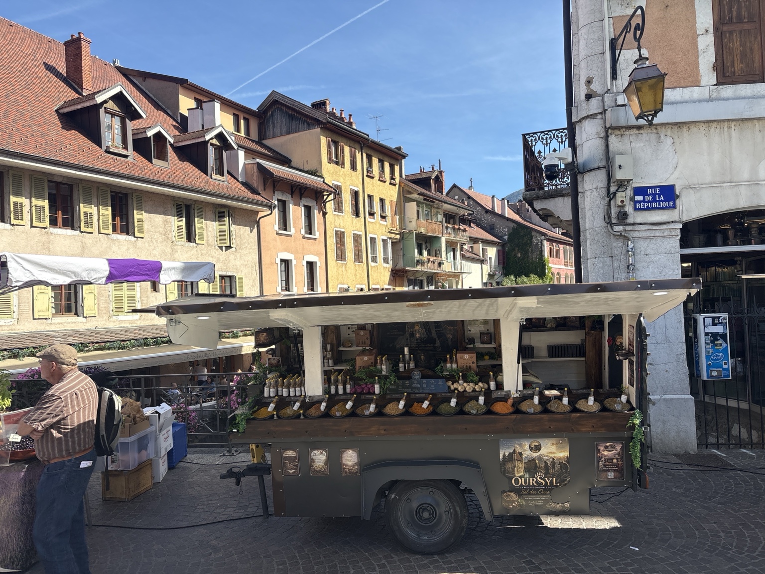 La roulotte La Brigade des Gourmands ouverte dans la vieille ville d’Annecy, avec les façades et les canaux en arrière-plan